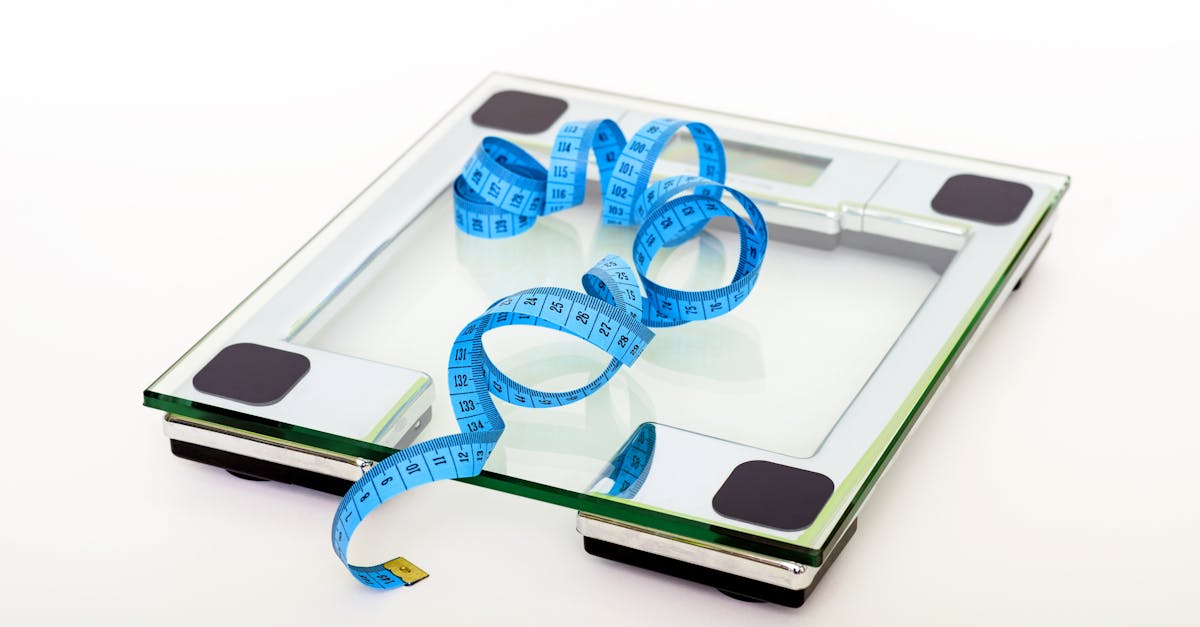 A digital glass weighing scale with a blue measuring tape, symbolizing weight management.