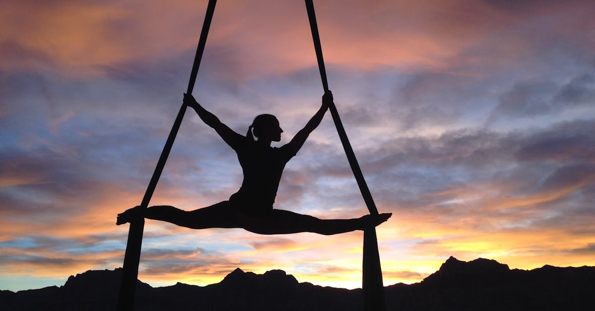 Silhouette of a woman practicing aerial yoga against a vibrant sunset sky in Las Vegas.